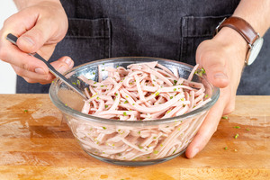 Wurstsalat mit dem Essig-Öl-Dressing vermischen