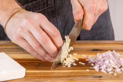 Knoblauch sowie Zwiebel würfeln