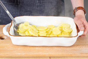 gekochte Kartoffelscheiben in die Auflaufform geben