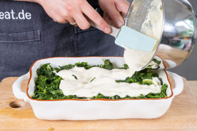Béchamelsauce über den Spinat verteilen
