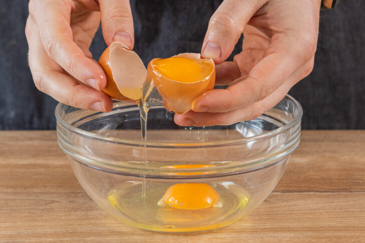 Eier in eine Schüssel geben