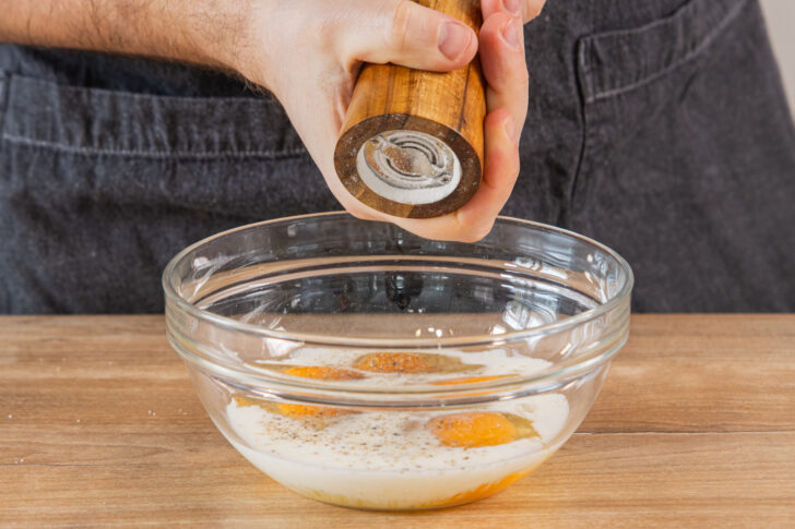 Ei-Milch-Mischung mit Salz und Pfeffer würzen