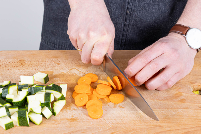 Zucchini und Karotten klein schneiden