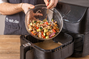 Grillgemüse in den Korb der Heißluftfritteuse geben