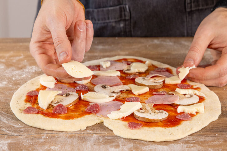 Mozzarella auf Valentins-Pizza legen