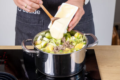 Schmelzkäse zur Käse-Lauch-Suppe mit Kartoffeln geben