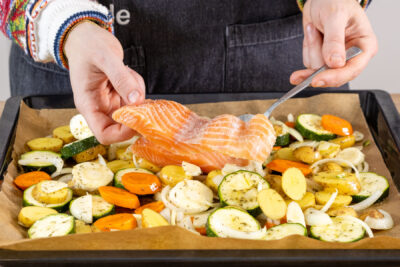Lachs auf das Kartoffel-Gemüse-Bett legen
