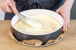 Quarkmasse als erste Schicht für die Eierschecke in die Springform geben