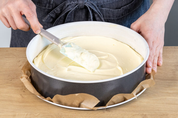 Quarkmasse als erste Schicht für die Eierschecke in die Springform geben