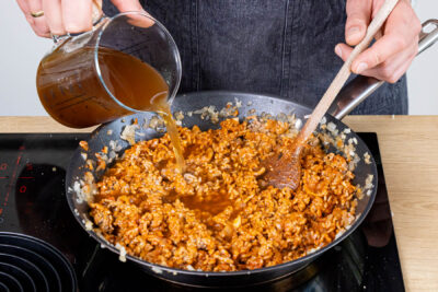 Rinderbrühe zum Hackfleisch gießen
