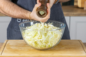Spitzkohlsalat mit Pfeffer würzen