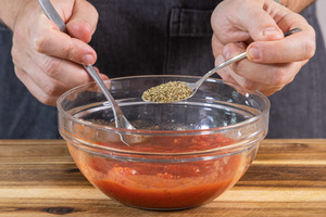 gehackte Tomaten aus der Dose mit Pizzagewürz würzen