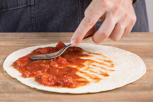 gehackte Tomaten auf der Tortilla verteilen