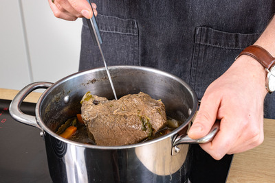 mit Fleischgabel prüfen, ob Rindfleisch gar ist