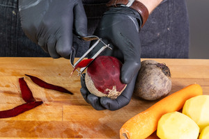 Rote Bete mit Handschuhen schälen