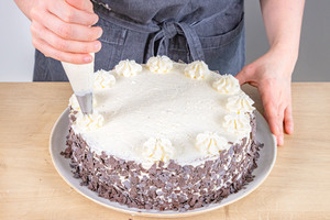 12 Sahnetuffs gleichmäßig auf klassischer Schwarzwälder Kirschtorte verteilen