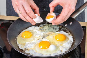 Eier in Pfanne zu Spiegeleiern braten