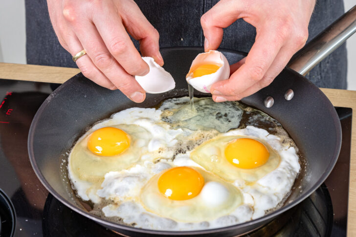 Eier in Pfanne zu Spiegeleiern braten