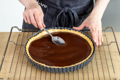 Schokocremefüllung auf dem Boden der Schokotarte verteilen