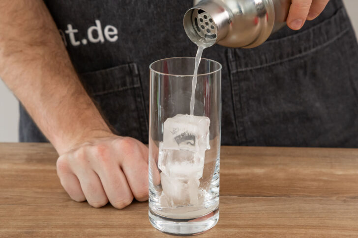 Cocktail durch Sieb gießen