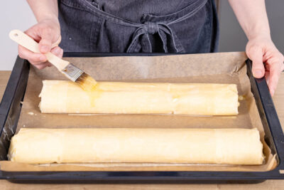 Topfenstrudel mit Butter bestreichen