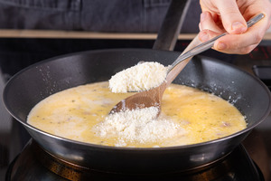 Parmesan zur Sahne-Soße geben