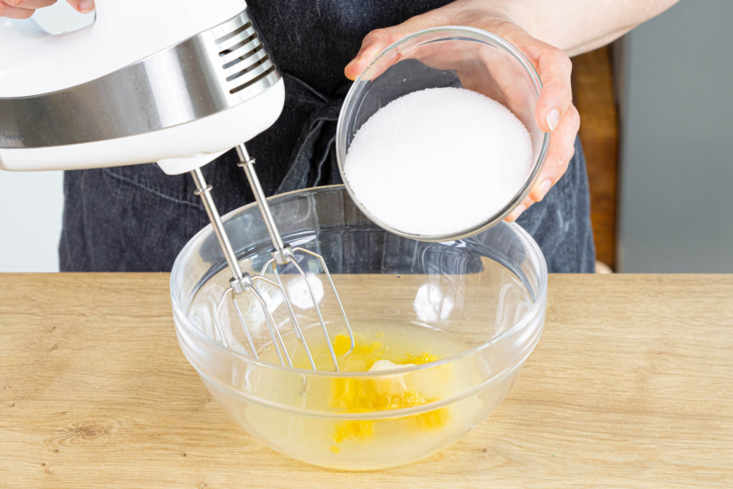 Zucker, Zitronensaft und -abrieb aufschlagen