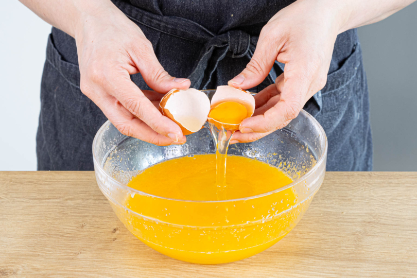 Eier und Sahne in die Zitronen-Zucker-Masse rühren