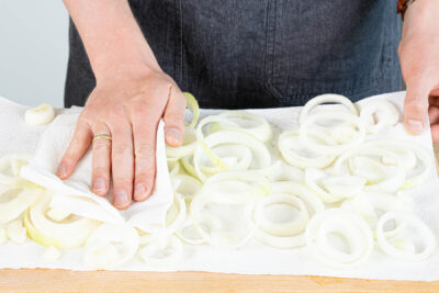 Zwiebelringe mit Küchenpapier abtupfen