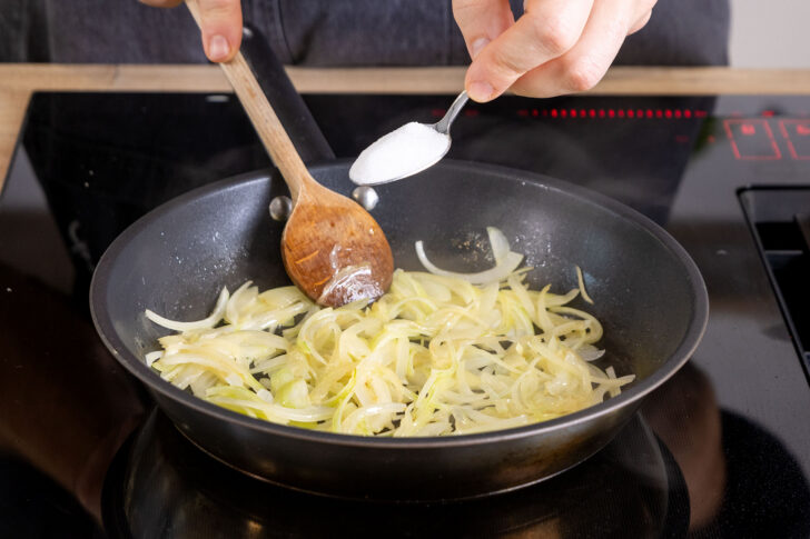 Zucker zu den Zwiebeln geben