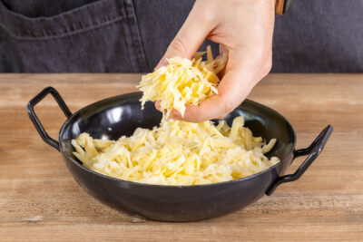 Käse über die Spätzle geben