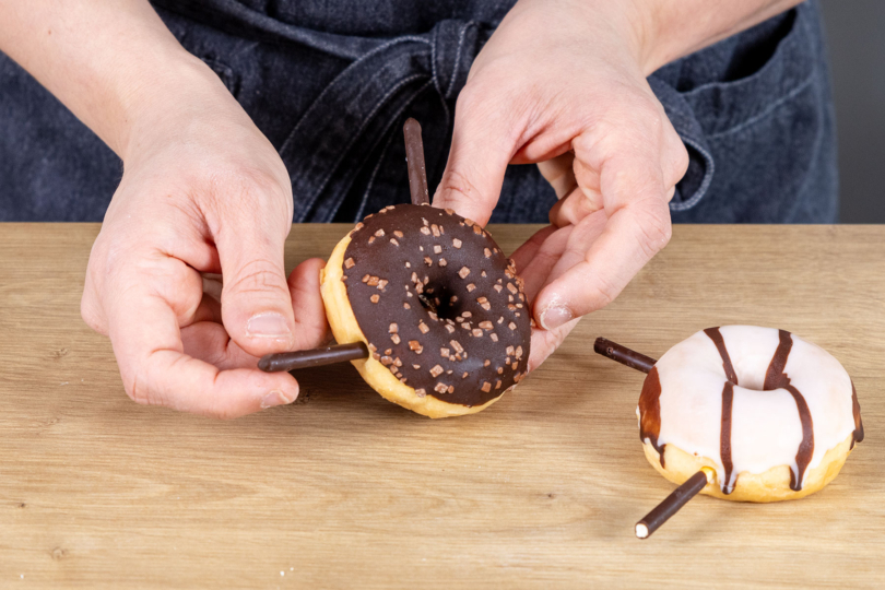 Schoko-Keks-Stäbchen in die Donuts stecken