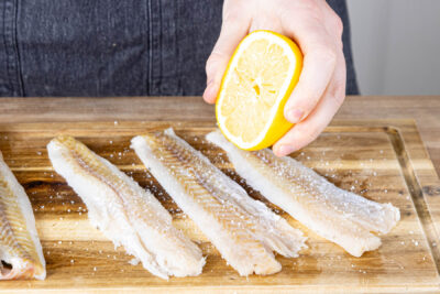 Seelachsfilet würzen und mit Zitronensaft beträufeln