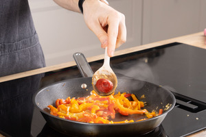 Tomatenmark in die Pfanne geben.