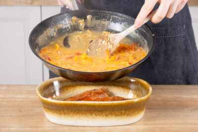 Paprikasauce über das Hähnchen geben.