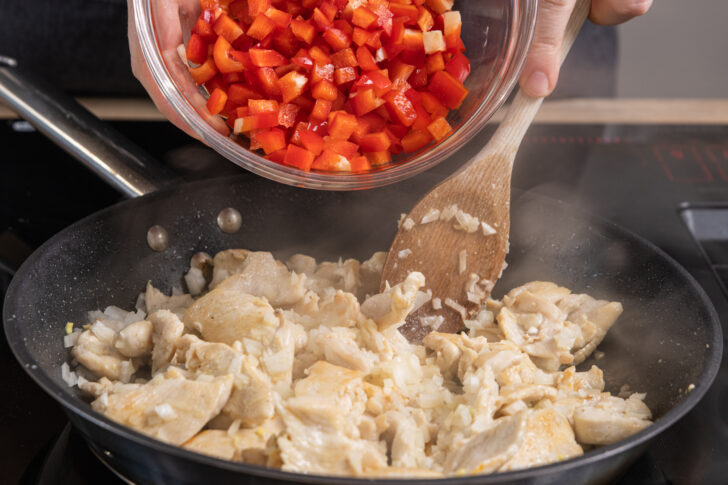 Paprika und Zwiebeln in die Pfanne geben