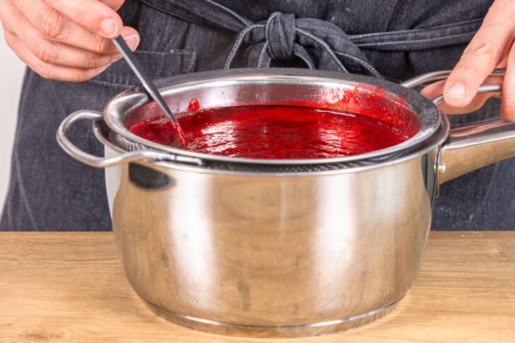 Himbeeren durch das Sieb streichen