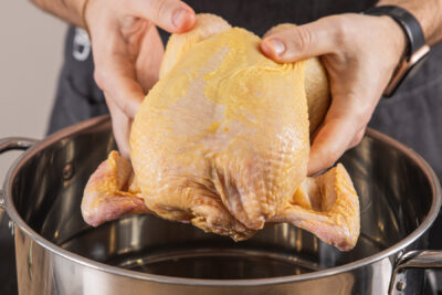 Suppenhuhn in den Topf geben