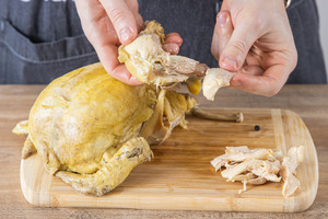 Suppenhuhn in mundgerechte Stücke zupfen