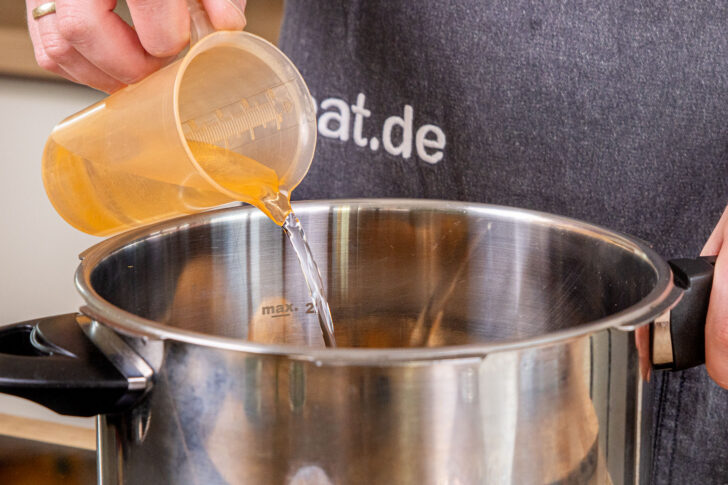 Wasser in den Topf gießen