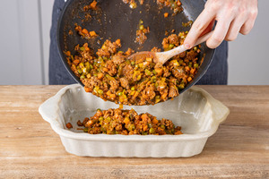 Hackfleisch-Masse in eine Auflaufform geben