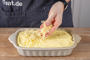 Kartoffelpüree-Auflauf mit Hackfleisch mit Käse bestreuen