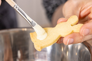 Etwas weiße Schokolade auf Hasen-Plätzchen geben