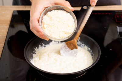 Parmesan in die Sahnesoße einrühren