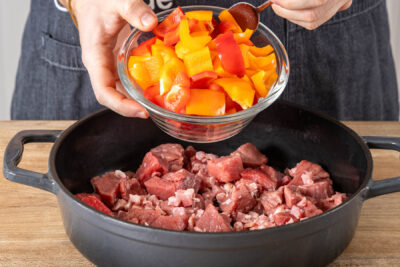 Gemüse und Fleisch in den Bräter geben