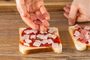 Salamiwürfel auf Toast geben