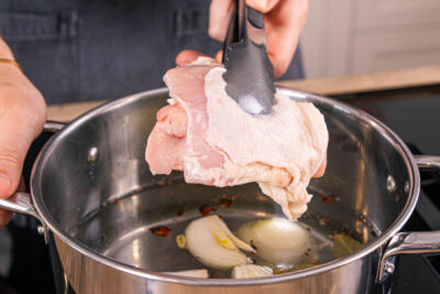 Hähnchenschenkel in dem Fond weich kochen