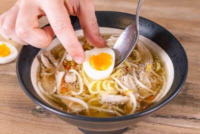 Eier halbieren und die Ramen mit Huhn und Ei garnieren