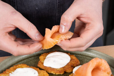 Den Lachs auf den Reibekuchen verteilen