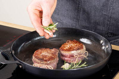 Knoblauch und Rosmarin mit in die Pfanne geben